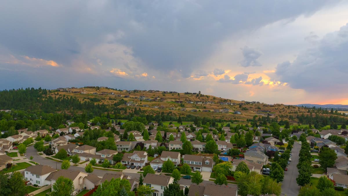 Tree-lined Liberty Lake streets from above, under a stormy summer sunset